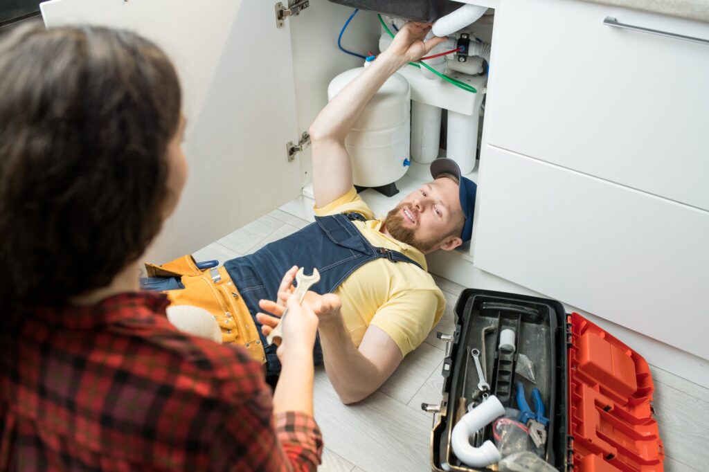 Handsome plumber fixing sink pipe